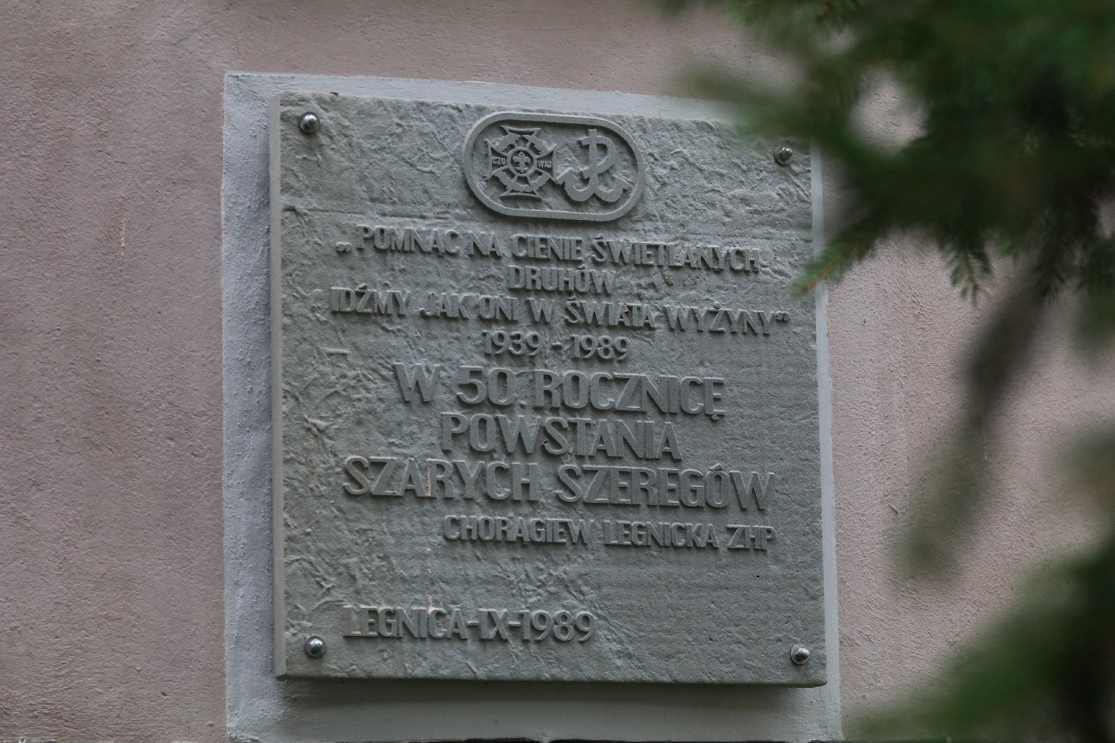 Kwiaty, znicze pod tablicą Szarych Szeregów w rocznicę powstania