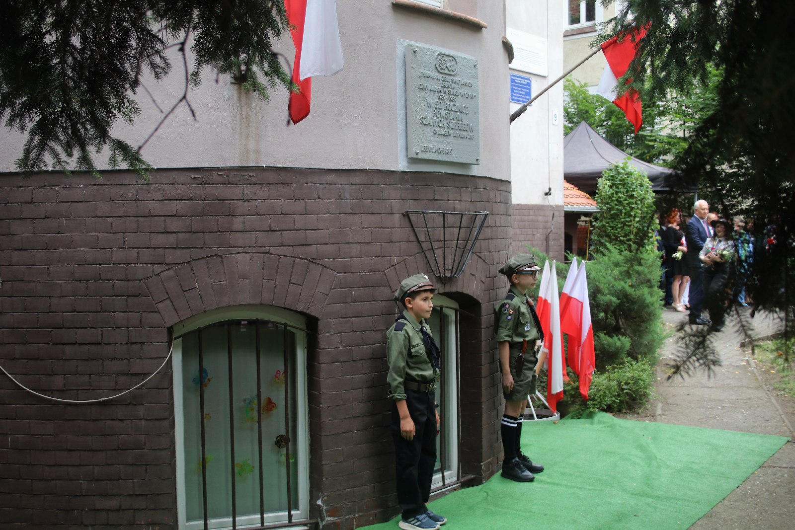 Kwiaty, znicze pod tablicą Szarych Szeregów w rocznicę powstania