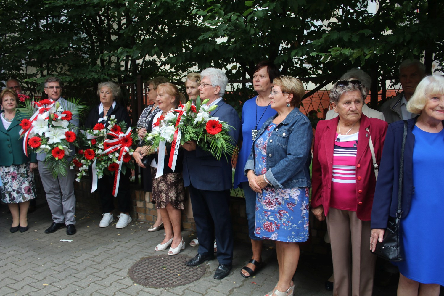 Kwiaty, znicze pod tablicą Szarych Szeregów w rocznicę powstania