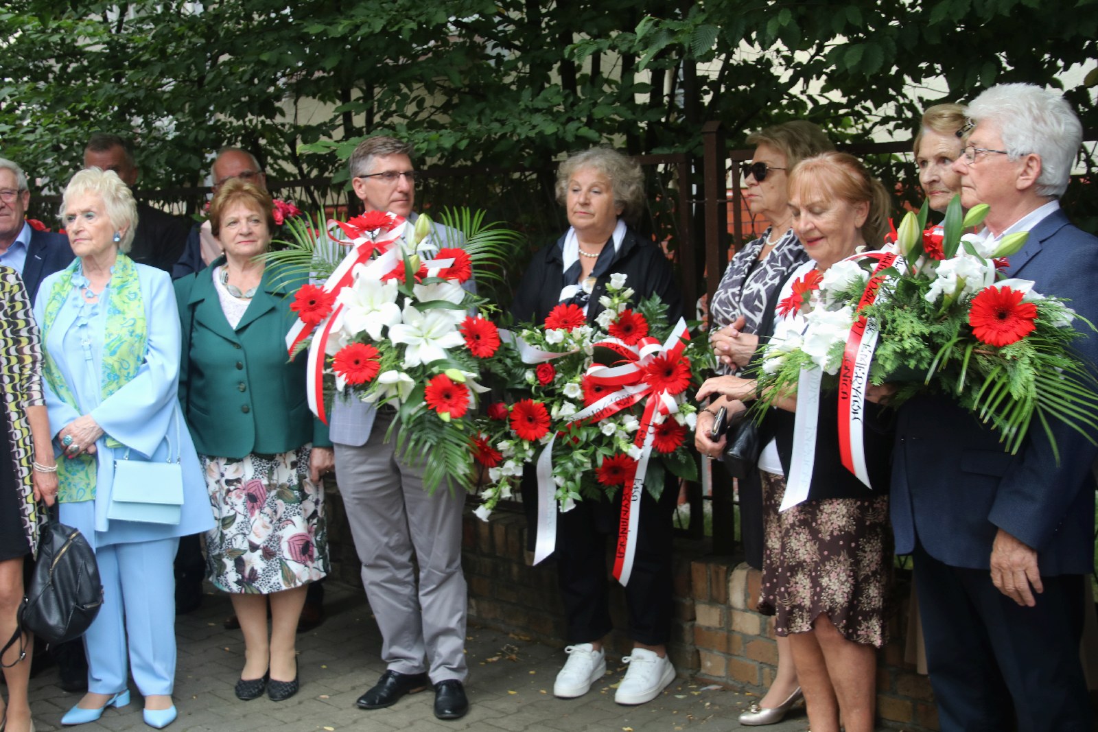 Kwiaty, znicze pod tablicą Szarych Szeregów w rocznicę powstania