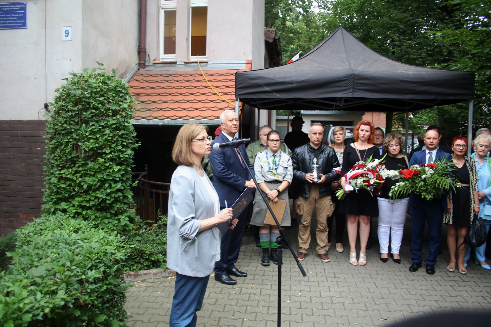 Kwiaty, znicze pod tablicą Szarych Szeregów w rocznicę powstania