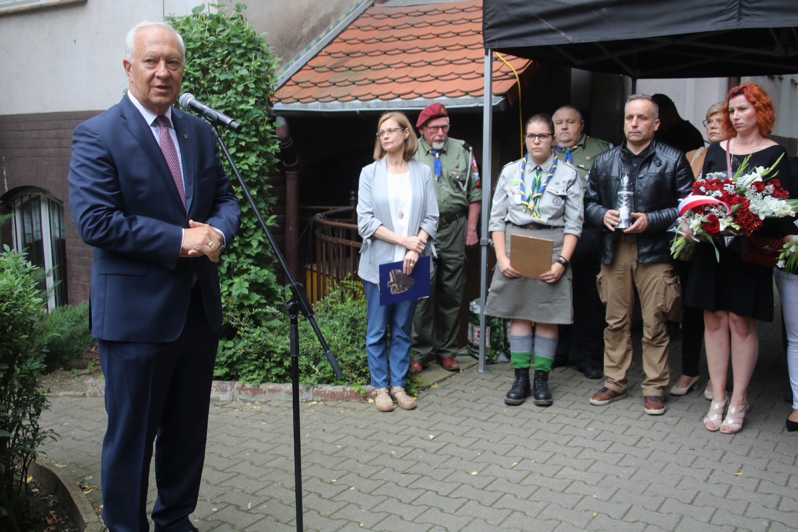 Kwiaty, znicze pod tablicą Szarych Szeregów w rocznicę powstania