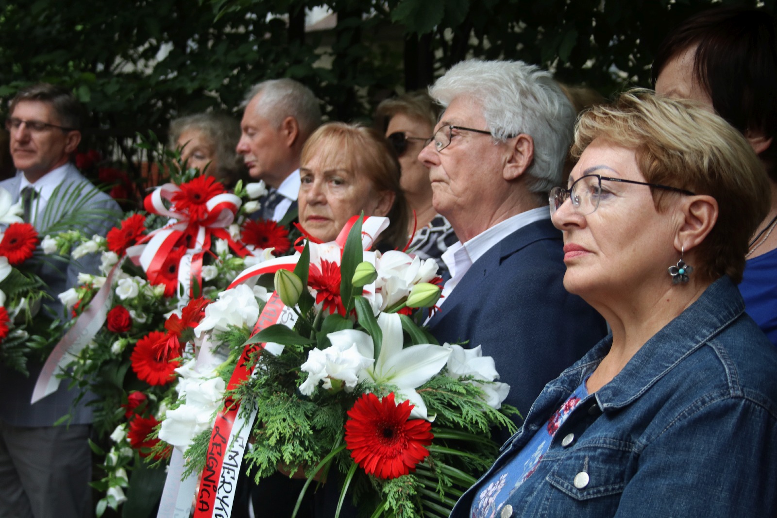Kwiaty, znicze pod tablicą Szarych Szeregów w rocznicę powstania