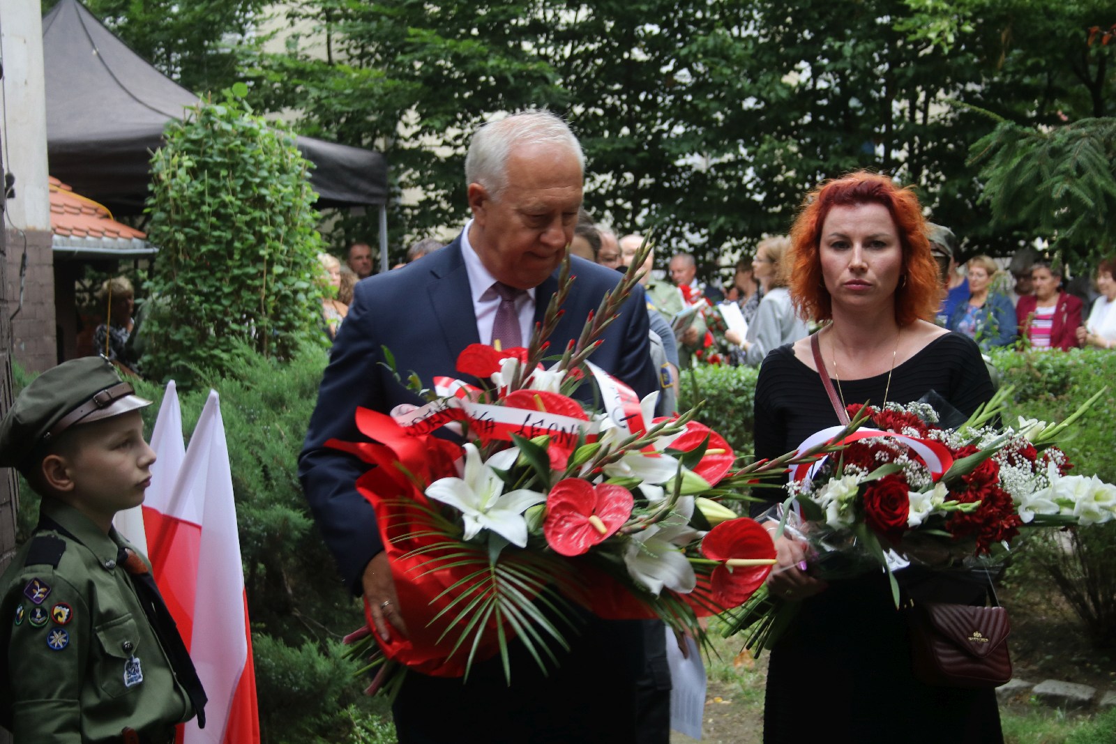 Kwiaty, znicze pod tablicą Szarych Szeregów w rocznicę powstania