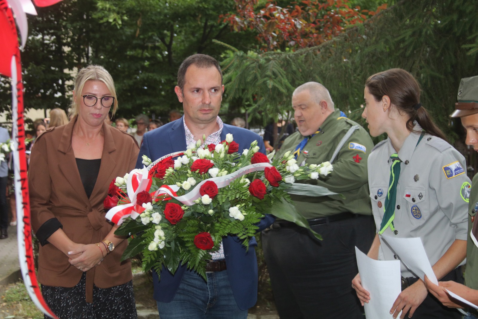 Kwiaty, znicze pod tablicą Szarych Szeregów w rocznicę powstania
