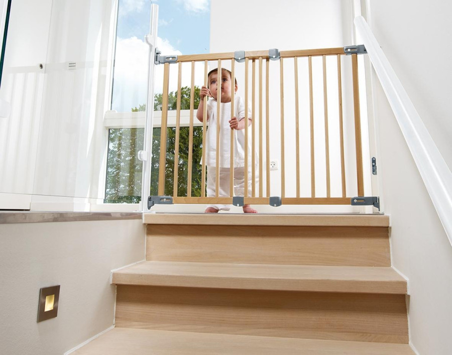 Dziecko stoi przed bramką zabezpieczającą schody