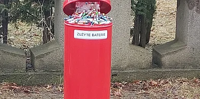 Przepełniony pojemnik i baterie w błocie na cmentarzu to zagrożenie